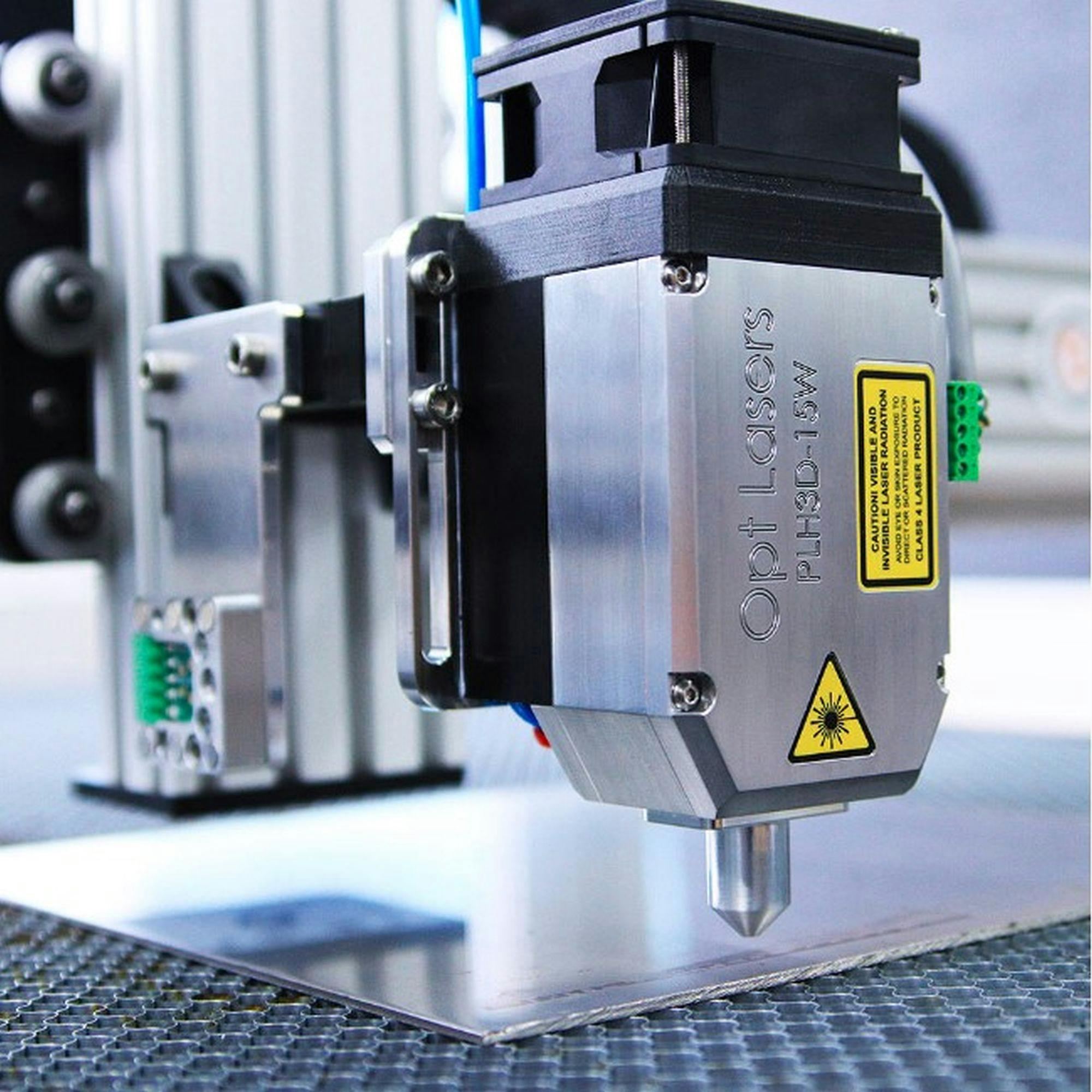 Laser processing head above a metal sheet